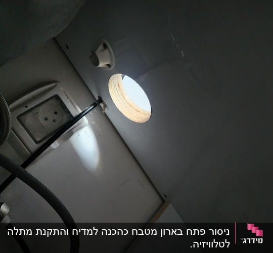 צינור מתכת ושקע חשמלי בארון מטבח